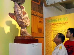 Khách tham quan chiêm ngưỡng ngói lợp góc tạo hình rồng thời Lý thế kỷ 11-12. (Ảnh: Thanh Tùng.TTXVN)